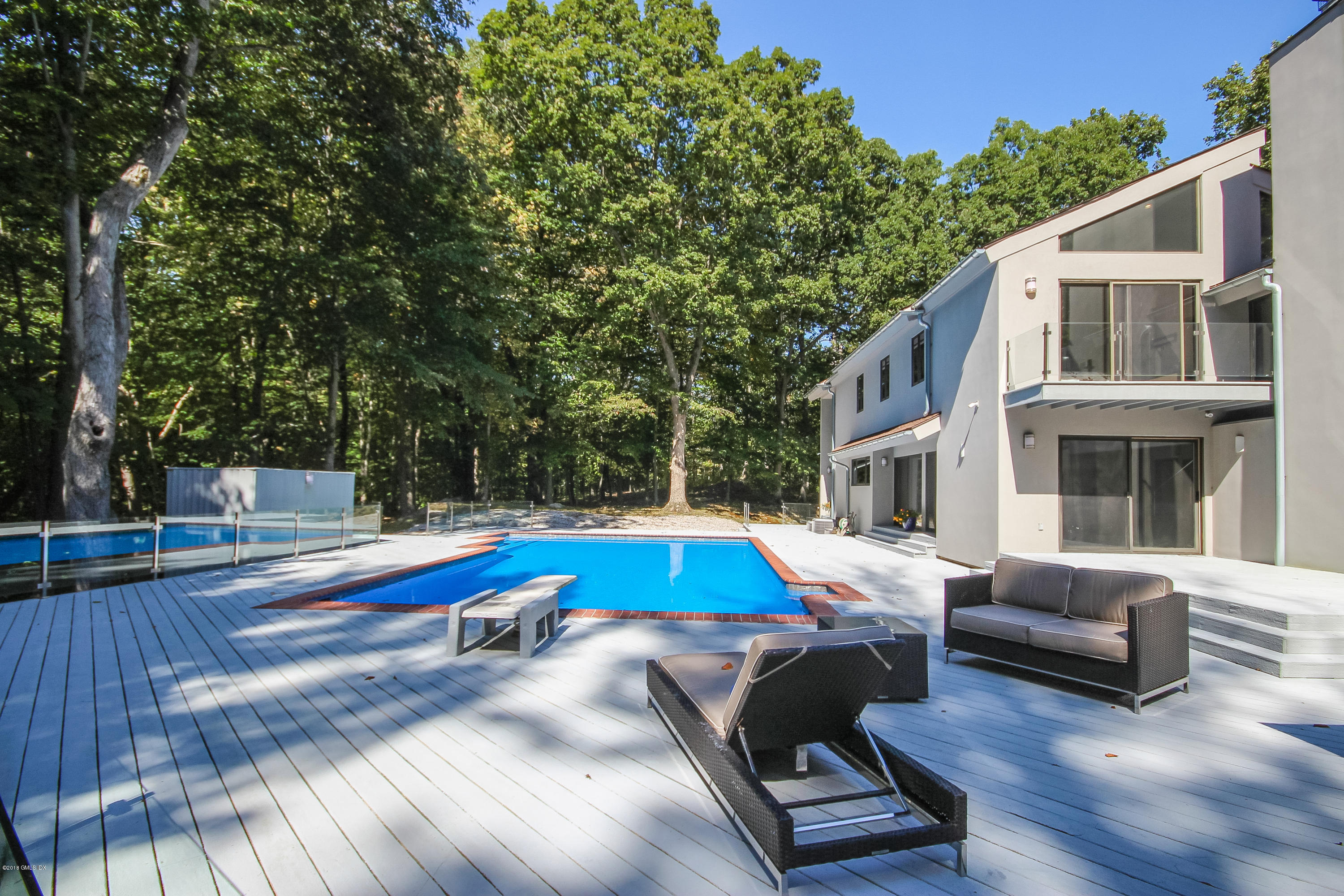 106 Porchuck Road Greenwich, CT 06831 - Photo 2 of 37 a view of a patio with couches table and chairs with wooden floor and fence