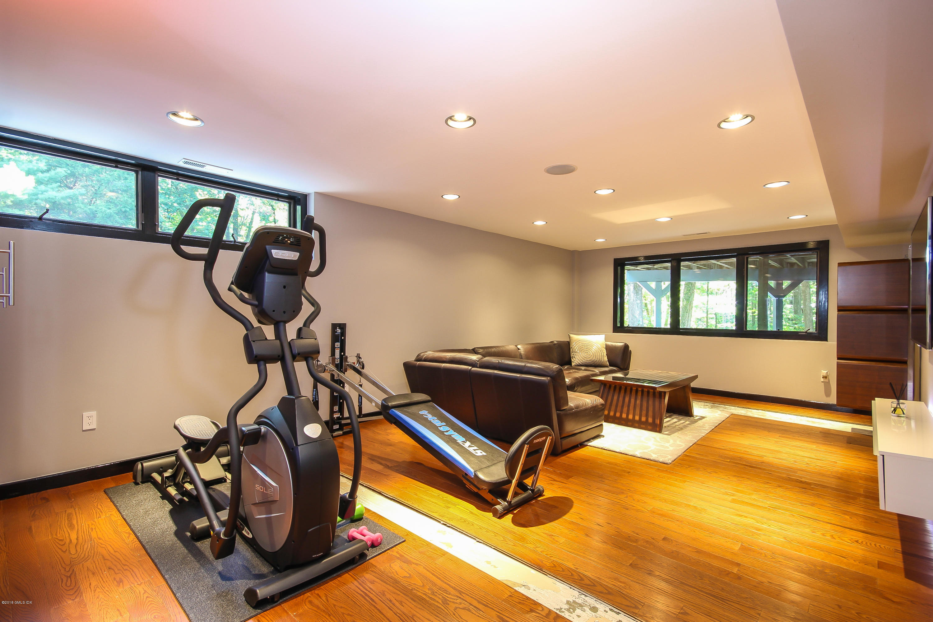 106 Porchuck Road Greenwich, CT 06831 - Photo 27 of 37 a living room with gym equipment and a large window