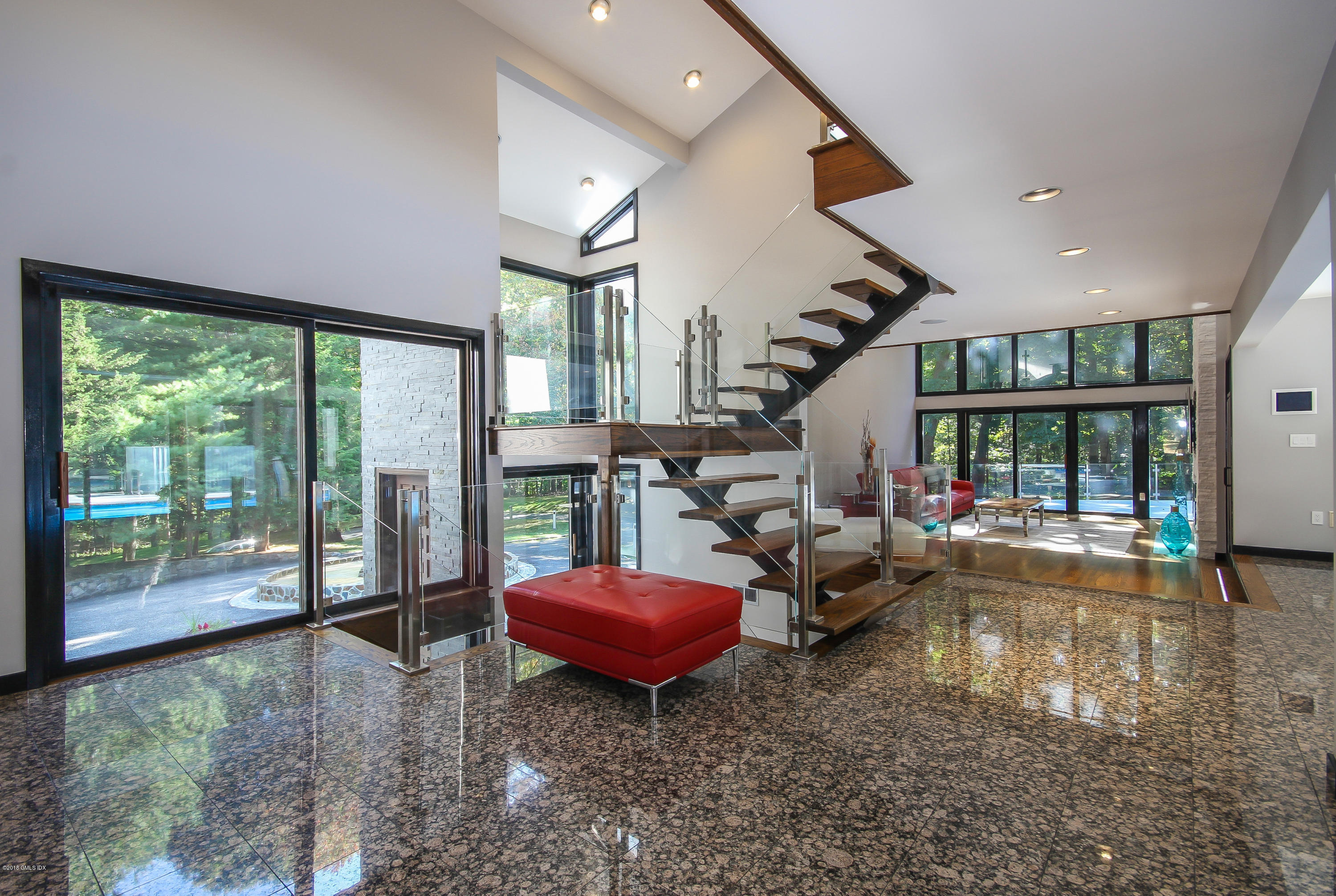 106 Porchuck Road Greenwich, CT 06831 - Photo 5 of 37 a living room with furniture stairs and a floor to ceiling window