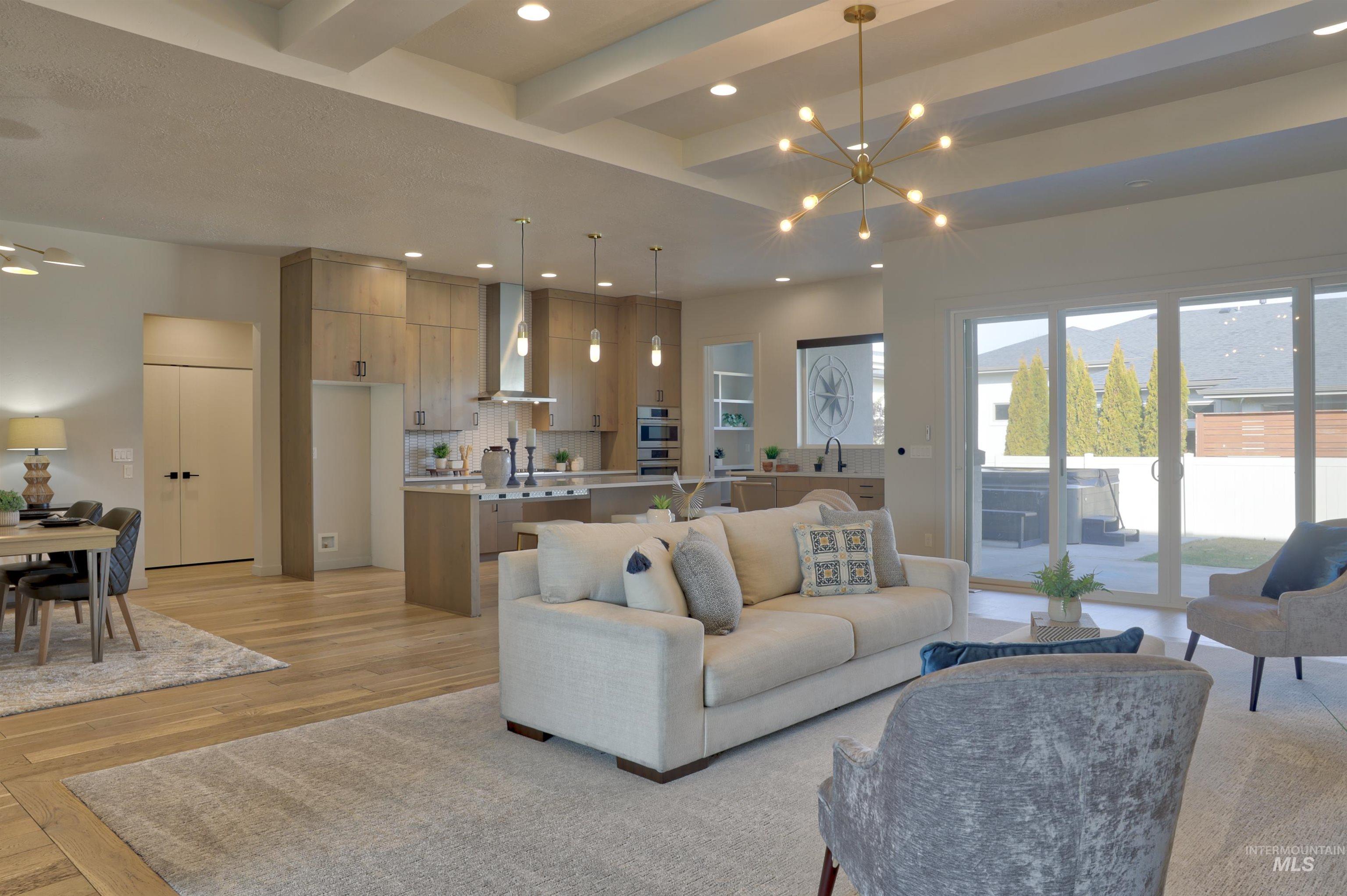 4148 East Copper Point Drive Meridian, ID 83642 - Photo 5 of 26 Living area with light wood finished floors, a chandelier, and beam ceiling