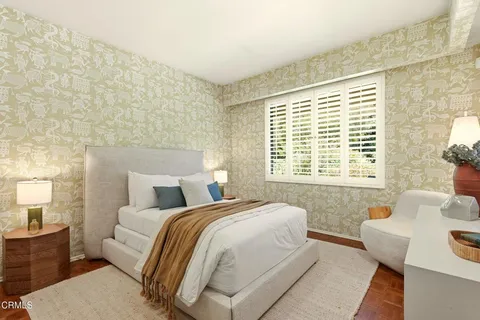 a bedroom with a bed and a large window