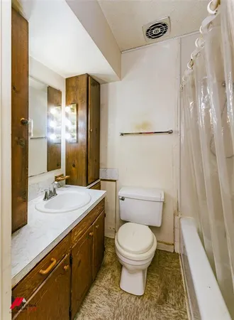 a bathroom with a granite countertop toilet sink and mirror