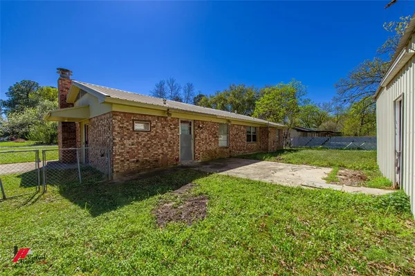 a view of a house with backyard and a patio
