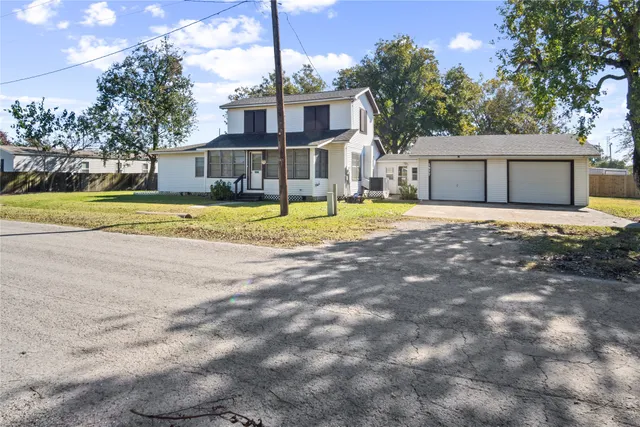 a front view of a house with a yard and trees