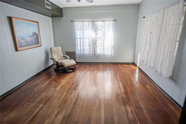 a living room with wooden floor and a window