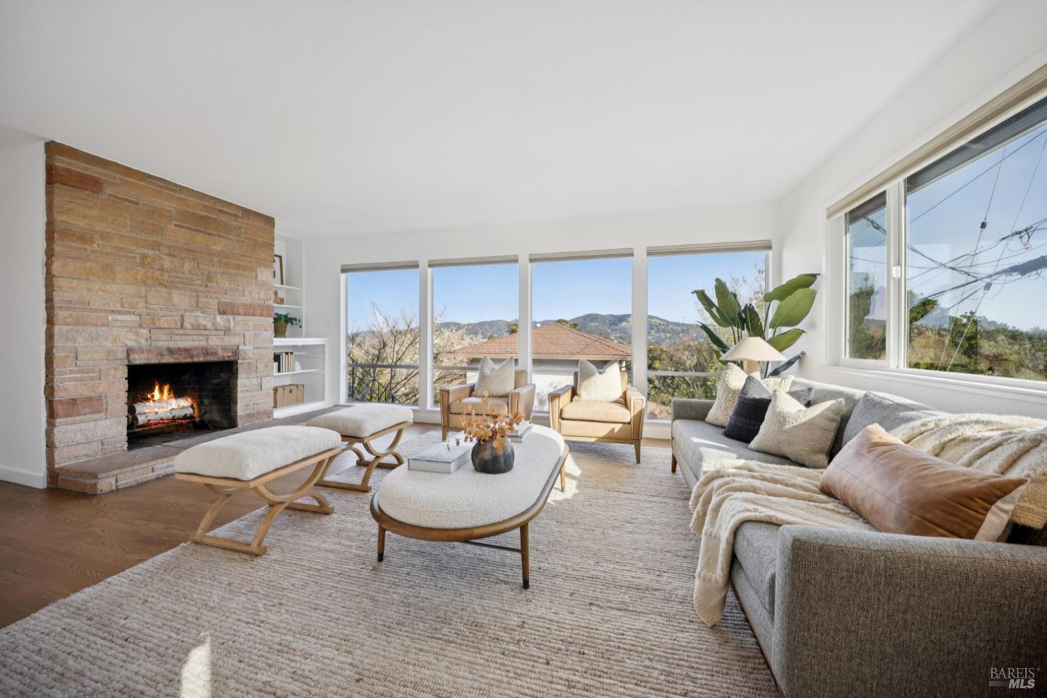 Spacious living area, with views of the hill and the bay. Remote controlled blinds, refinished hardwood floors, built in shelves and flagstone fireplace. Please note the flames in the FP were digitally added.