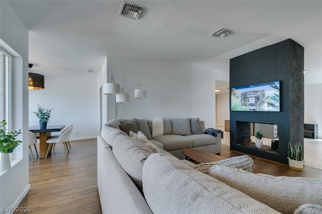 892 North Hollywood Boulevard Las Vegas, NV 89110 - Photo 17 of 81 Bright, spacious open concept living area with fireplace and natural wood flooring.