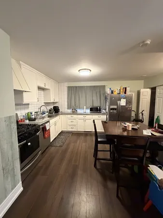 a kitchen with a table chairs stove and cabinets