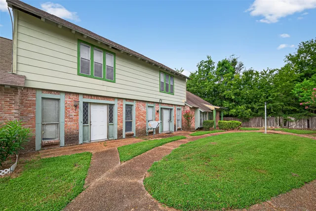 a front view of a house with a yard and trees