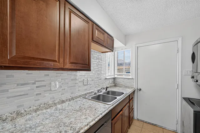a kitchen with stainless steel appliances granite countertop a sink and a refrigerator