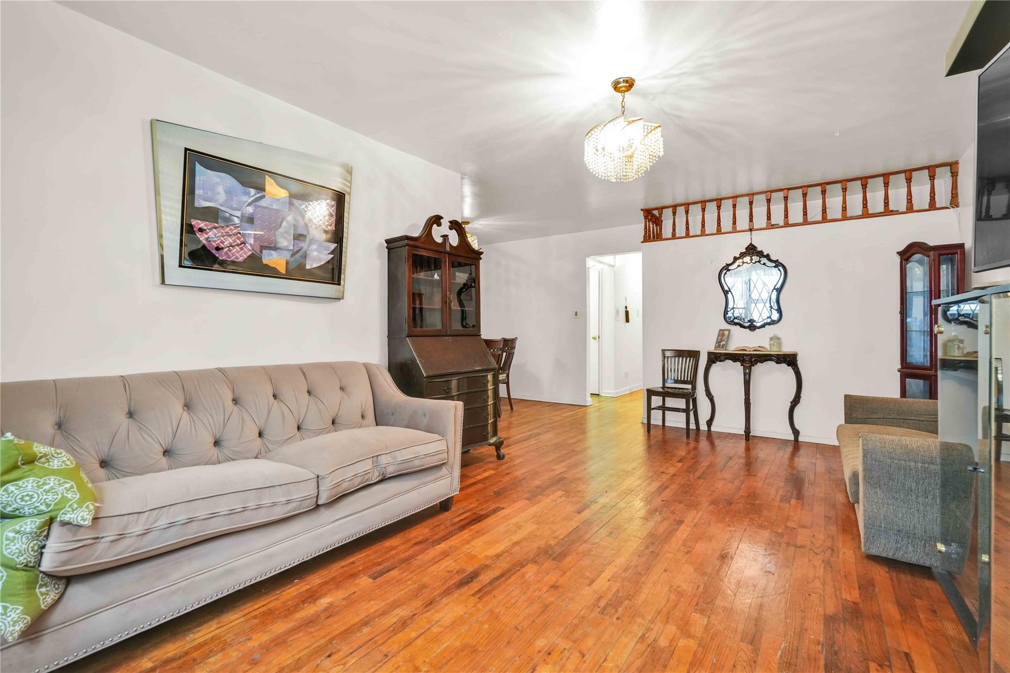 42-25 80th Street, Unit 1F Queens, NY 11373 - Photo 8 of 27 Living room featuring hardwood / wood-style floors and an inviting chandelier