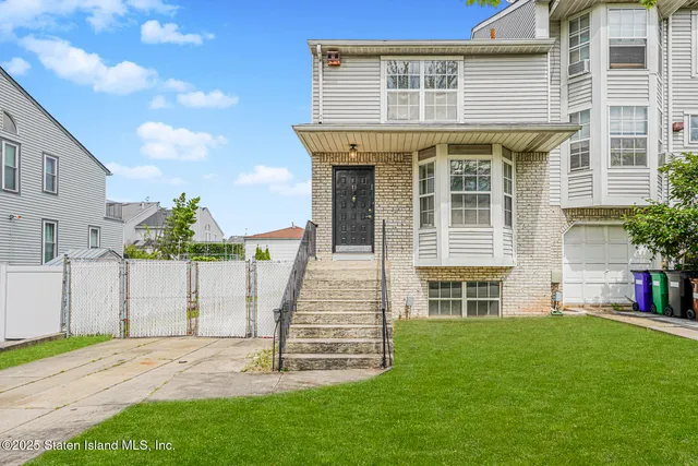 a front view of a house with a garden and plants