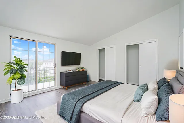 a bedroom with a balcony a bed and a flat screen tv