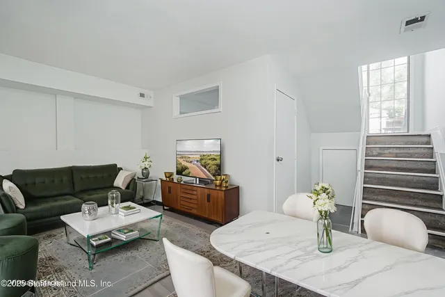 a living room with furniture a rug and a window