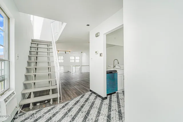 a view of a hallway with wooden floor and entryway