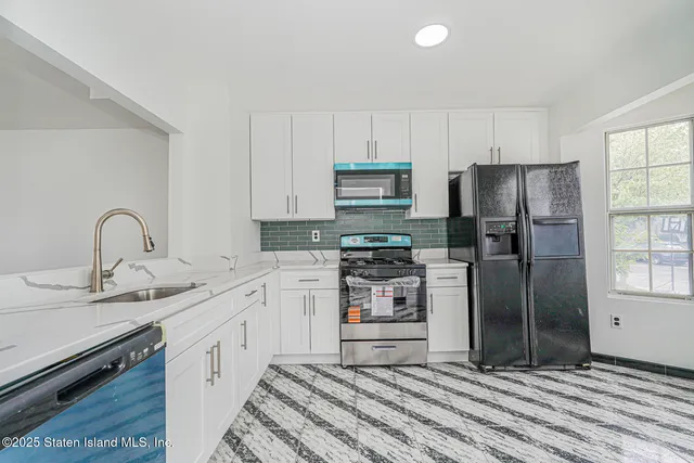 a kitchen with stainless steel appliances granite countertop a refrigerator sink and stove