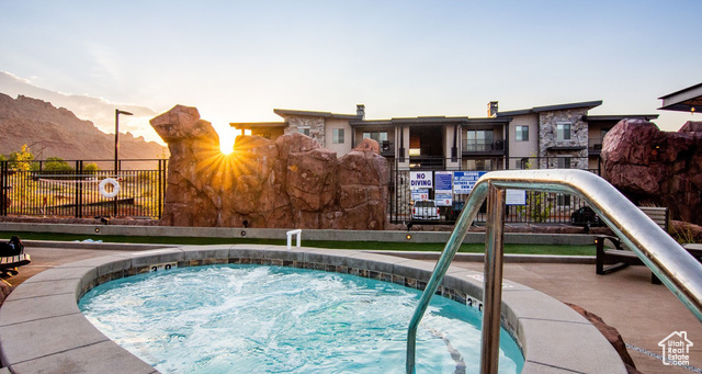 2331 Mesa Road, Unit E3 Moab, UT 84532 - Photo 49 of 71 Pool at dusk with a hot tub, a mountain view, a patio, and a swimming pool