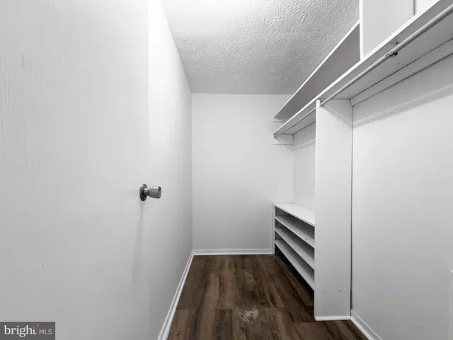 a view of walk in closet with wooden floor