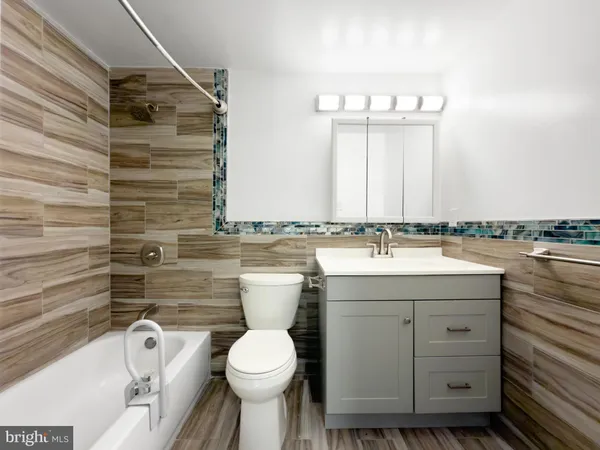 a bathroom with a granite countertop sink toilet and mirror