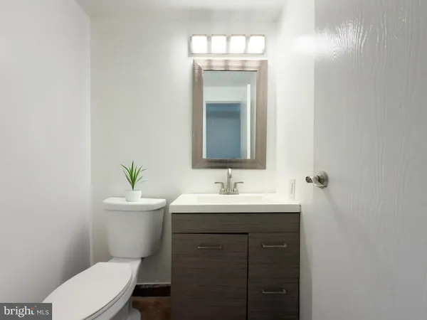 a bathroom with a toilet a sink and mirror