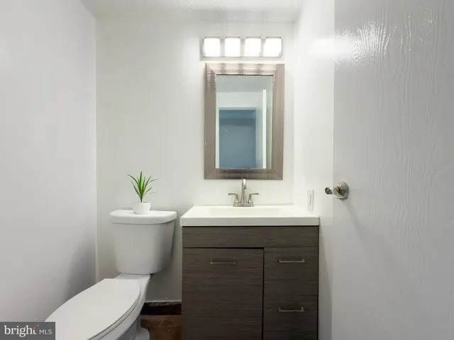 a bathroom with a toilet a sink and mirror