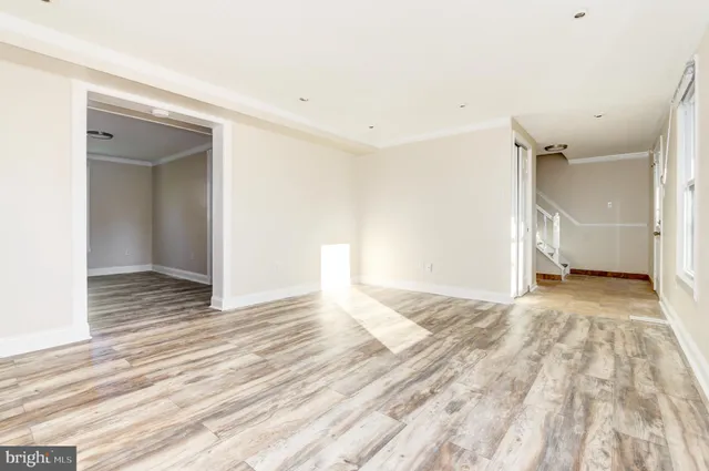 a view of a livingroom with wooden floor and staircase