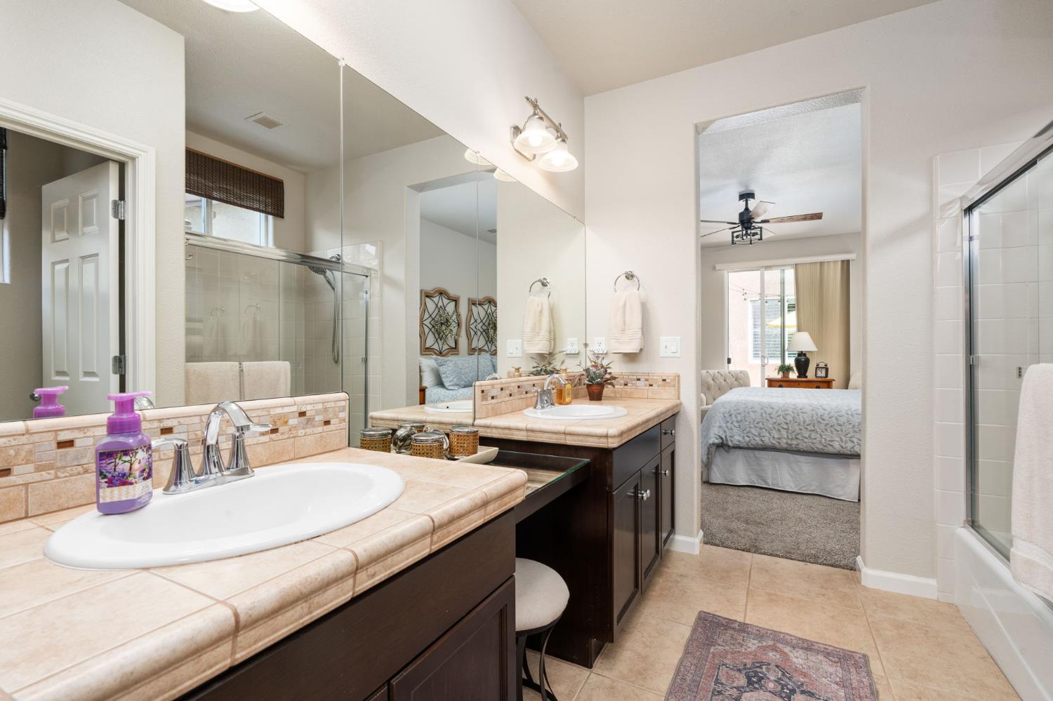 3942 Harlan Ranch Boulevard Clovis, CA 93619 - Photo 12 of 21 a en suite bathroom with a granite countertop sink and a mirror