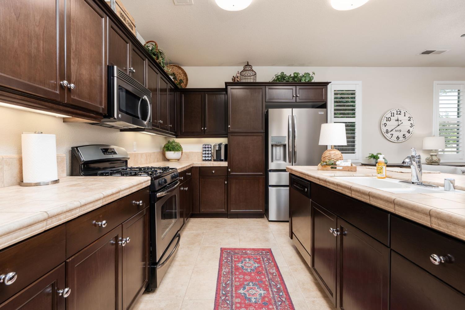 3942 Harlan Ranch Boulevard Clovis, CA 93619 - Photo 5 of 21 a kitchen with stainless steel appliances granite countertop a sink a stove and a refrigerator