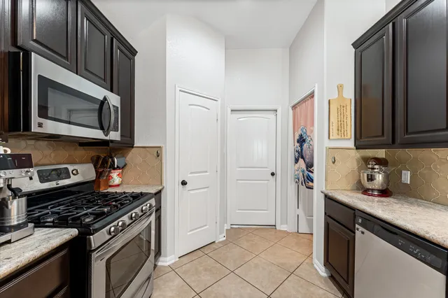 a kitchen with stainless steel appliances granite countertop a stove microwave refrigerator and sink