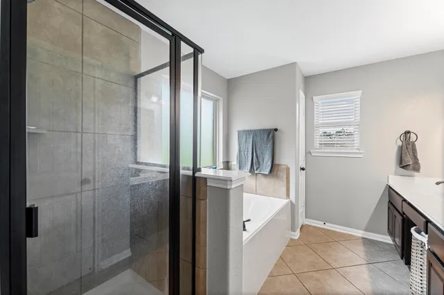 a bathroom with a tub sink and mirror