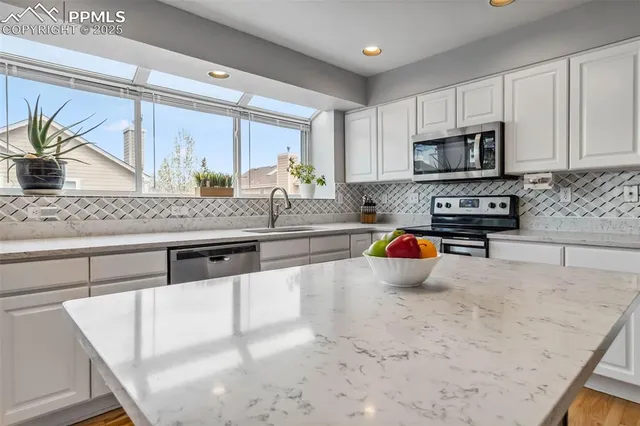 a kitchen with stainless steel appliances granite countertop a sink stove and refrigerator