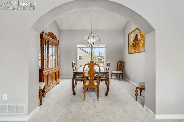 a view of a dining room with furniture and chandelier