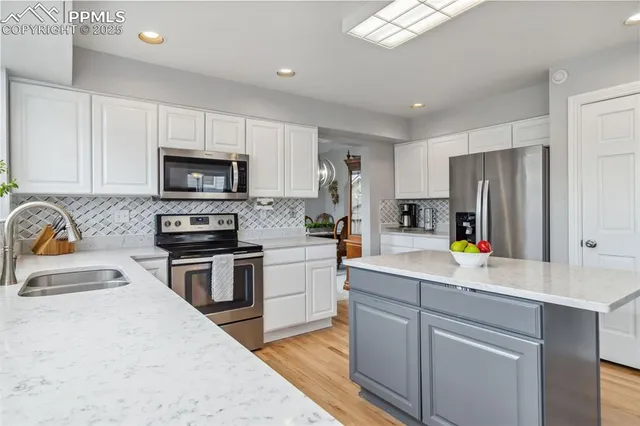 a kitchen with appliances a sink cabinets and a counter top space