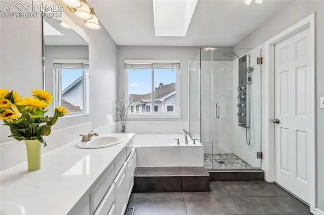 a spacious bathroom with a tub sink and mirror