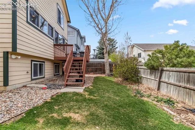 a view of a house with backyard and wooden fence