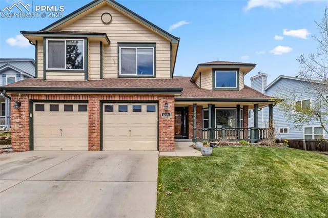 a front view of a house with a garden and plants