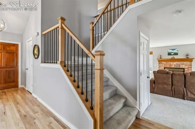 a view of a hallway with wooden floor and staircase