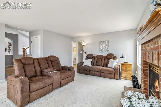 a living room with furniture a fireplace and a flat screen tv