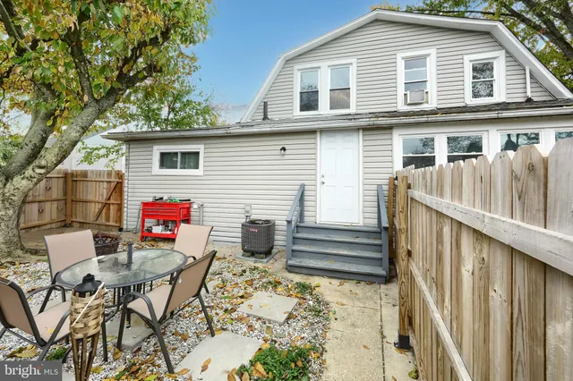 a backyard of a house with wooden deck and furniture