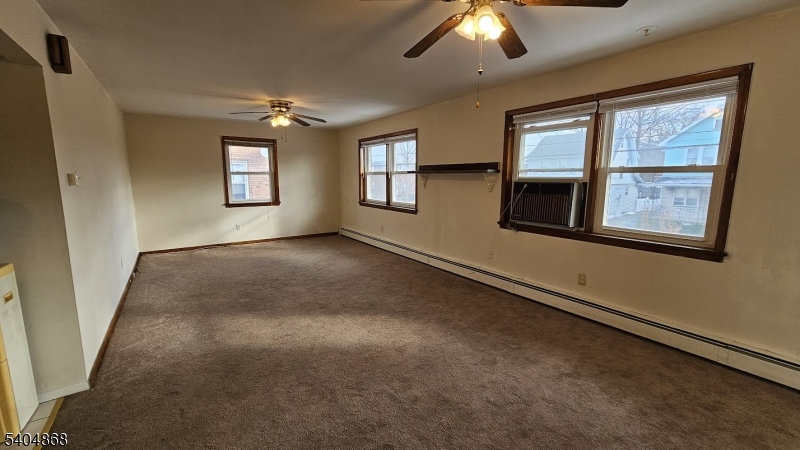 an empty room with windows and ceiling fan