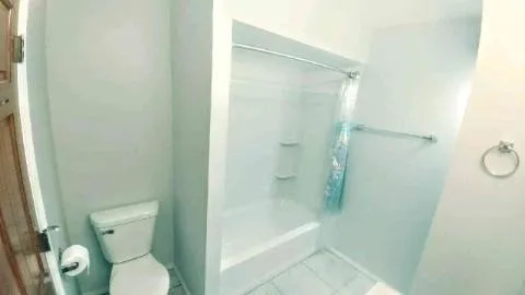 a bathroom with a toilet and a shower
