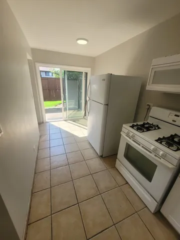 a kitchen with a stove a refrigerator and a counter top space