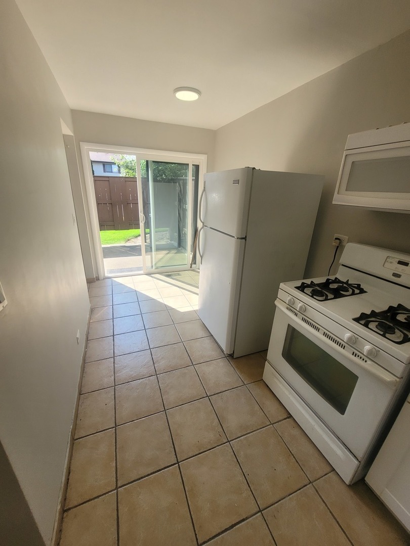 2 Tower Court Downers Grove, IL 60516 - Photo 4 of 20 a kitchen with a stove a refrigerator and a counter top space