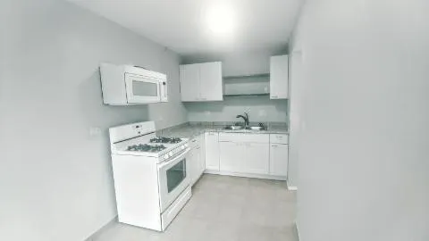 a kitchen with a stove top oven sink and cabinets