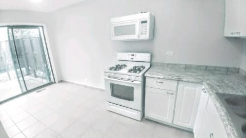 2 Tower Court Downers Grove, IL 60516 - Photo 6 of 20 a kitchen with white cabinets and a stove