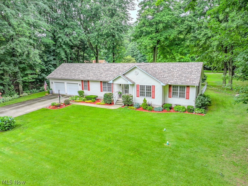 1966 Spring Grove Madison, OH 44057 - Photo 1 of 50 New Roof (2025), complements a lush yard surrounded by a tree canopy around the perimeter
