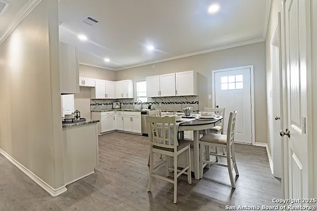 a kitchen with a table chairs refrigerator and cabinets