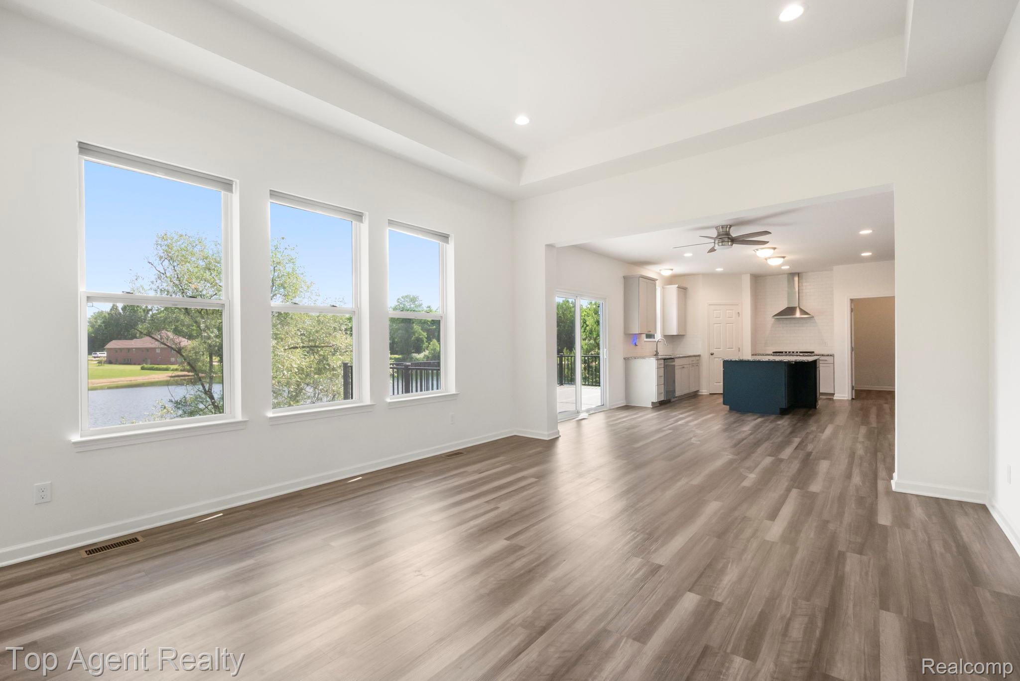 63770 Dequindre Road Washington, MI 48095 - Photo 11 of 61 Spacious living area with wood-finish flooring, recessed lighting, and a tray ceiling