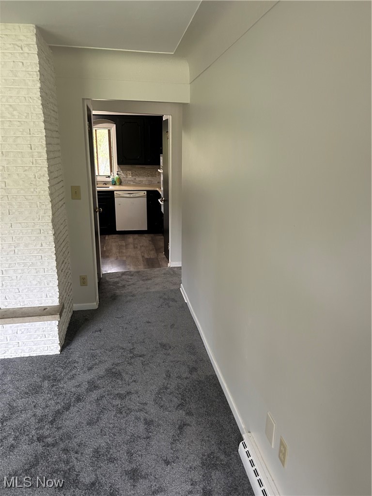 8223 Montello Road Independence, OH 44131 - Photo 10 of 28 Corridor featuring dark colored carpet, baseboard heating, and brick wall