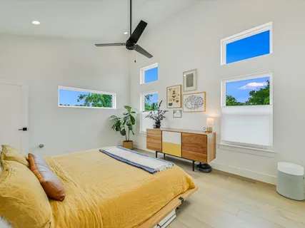 a bedroom with a bed dresser and wooden floor